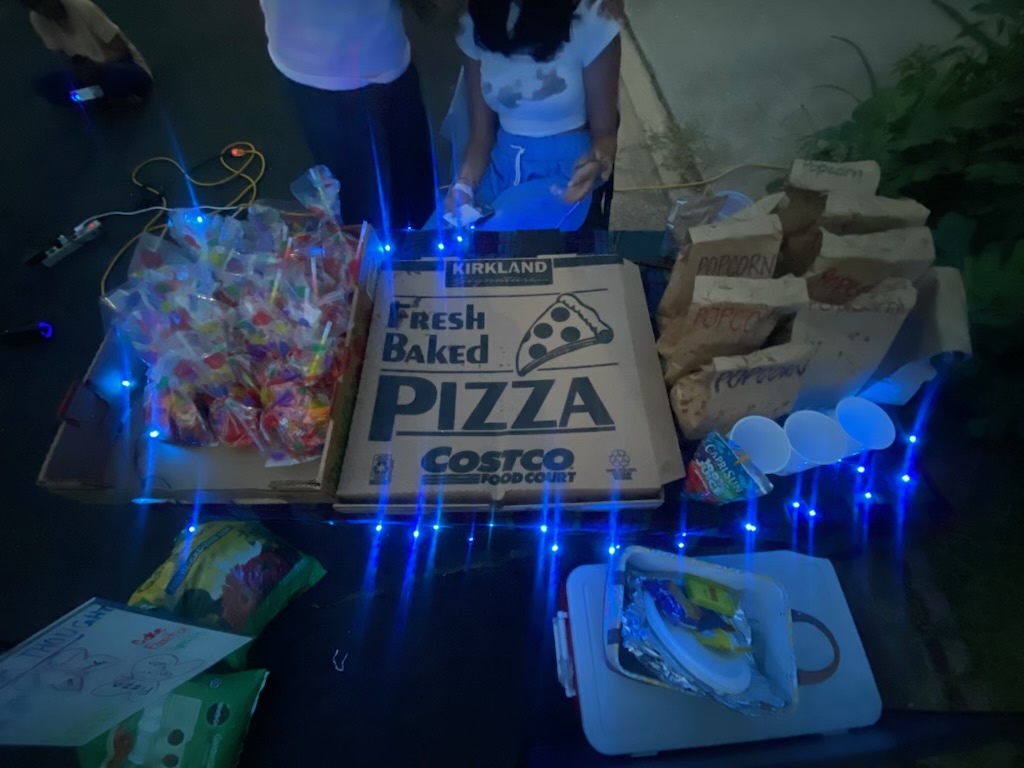 A pizza and snack table prepared for a community fundraiser.